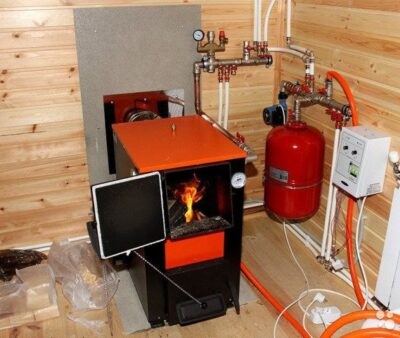 Твердотопливный котел в котельном помещении на даче